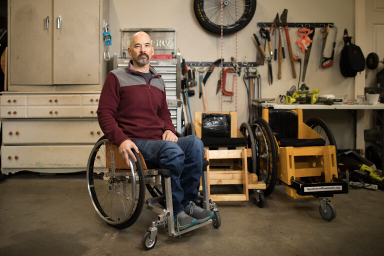 Erik in his garage next to his DIY wheelchairs.